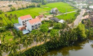 会安Haemer Villa Hoi An的享有棕榈树和河流的度假胜地的空中景致