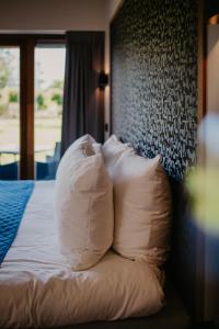 KapelleMotel-Restaurant-Grand Cafe de Caisson的一张带白色枕头的床
