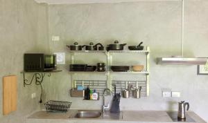他朗PHUKET THALANG POOL VILLA的厨房配有水槽和储物架,包括锅碗瓢盆