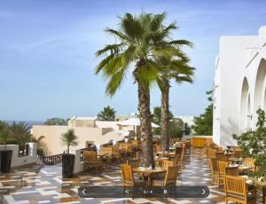 拉斯阿尔卡麦Peaceful Private Villa at Five Star Beach Resort的一个带桌椅的庭院,棕榈树