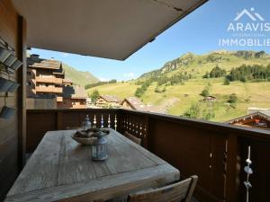 大博尔南Appartement Le Grand-Bornand, 3 pièces, 4 personnes - FR-1-391-5的山景阳台上的木桌