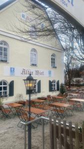 慕尼黑Alter Wirt Ramersdorf的前面有一张桌子的建筑