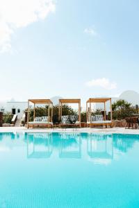费拉天文宫套房酒店的一个带椅子和凉亭的大型游泳池