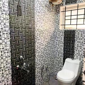 科代卡纳尔Kalyani Homestay的浴室设有卫生间,铺有黑白瓷砖。