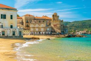 圣塔马里亚迪卡斯特Esclusivo alloggio a sfioro sul mare con terrazza.的海滩上一群建筑