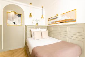 巴黎Luxury 2 bedrooms Apartment - Louvre Museum的卧室配有一张床,墙上挂有绘画作品