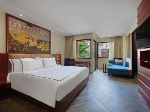 芭东海滩Novotel Phuket Vintage Park Resort的一间带白色床的卧室和一间客厅