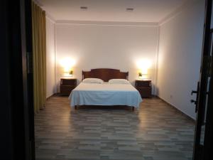 米瑞莎Hotel La Felicita的一间卧室配有一张床,两盏台灯放在两张桌子上