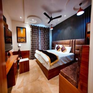罗塔克Hotel Joylife- Chottu Ram Chowk Rohtak Haryana的一间卧室配有一张床、一张书桌和一台电视