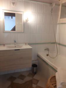 卡西斯Appartement le Mehari的一间带水槽、浴缸和镜子的浴室