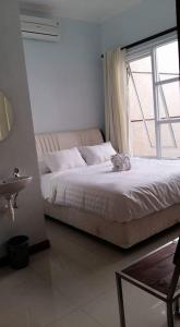 万隆G10 Guest House Near Asia Afrika Bandung的一间卧室设有一张大床和窗户