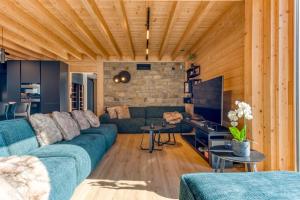 特纳维耶Villa Wood - Gîte de prestige en Ardennes - 10 personnes - Sauna, jacuzzi, piscine et billard的客厅设有蓝色的沙发和木制天花板。