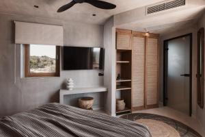 卡瓦拉Myra Hotel的一间卧室设有一张床、一台电视和一个窗口。