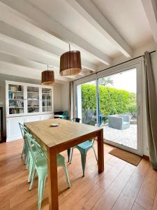 克罗宗Maison familiale 11 couchages, proche de La Palue的一间带木桌和绿色椅子的用餐室