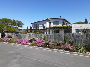 努尔德霍克Selkie - Two Restful Studio Apartments near Noordhoek Beach & Restaurants的路边有围栏和鲜花的房子