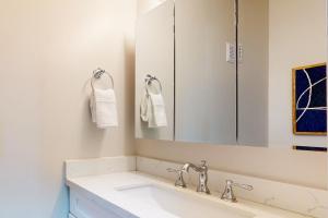 塔科马Tacoma Garden Hideaway的白色的浴室设有水槽和镜子