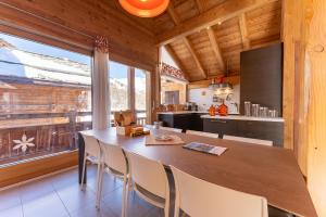 瓦尔Chalet Mountainside avec sauna et jacuzzi à 200m des pistes的厨房配有大型木桌和椅子