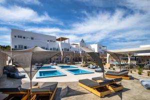 卡特瑞杜斯Aelia Luxury Suites的一个带游泳池和椅子的度假胜地和一座建筑