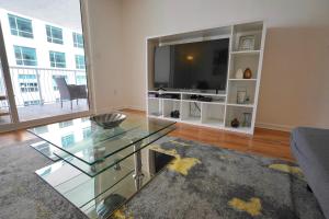 迈阿密City & Sea View+FREE Parking Modern Condo的客厅配有玻璃桌和平面电视。