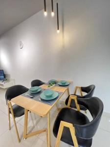 努沙再也Teega Suites #3101 Puteri Harbour Iskandar Puteri的一间带桌子和黑色椅子的用餐室