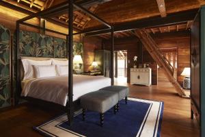 清迈Aleenta Retreat Chiang Mai的一间卧室配有一张天蓬床和蓝色地毯