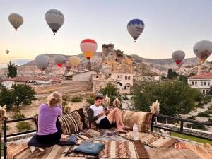 格雷梅Jacob's Cave Suites - Cappadocia的坐在沙发上看热气球的夫妇
