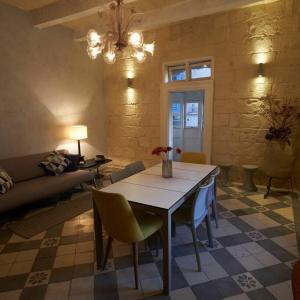 瓦莱塔House of Character in Valletta的客厅配有桌椅和沙发