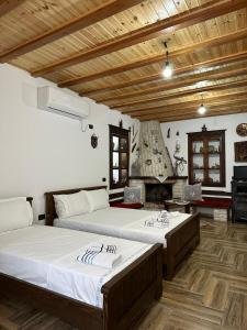 培拉特Guest House Iljesa的一间卧室设有两张床和一个壁炉