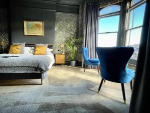 伊尔弗勒科姆The Earlsdale Bed and Breakfast的一间卧室配有一张床和一张蓝色椅子