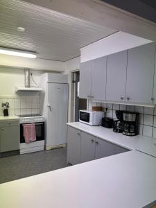 维斯比Traume vandrarhem的厨房配有白色橱柜和白色冰箱。