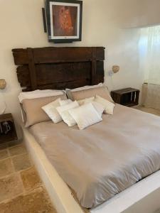 洛科罗通多trulli mancinella的一张配有白色床单和枕头的大床