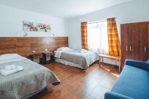 圣佩德罗·德·阿塔卡马Peumayen Atacama cabaña&Hostal的酒店客房,设有两张床和一张沙发