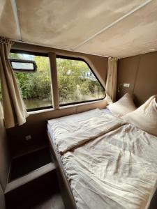 贝尔恩卡斯特尔-库斯KL Moselboote - Hausboot Niara的一张位于野营车后面的床位,带窗户
