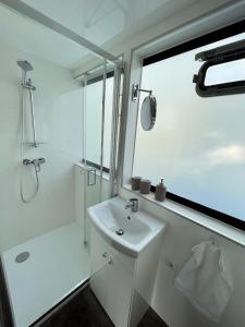 贝尔恩卡斯特尔-库斯KL Moselboote - Hausboot Niara的白色的浴室设有水槽和淋浴。