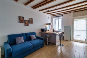 米兰Duomo in 10 minutes - modern close to Cadorna Station的一间带蓝色沙发的客厅和一间厨房