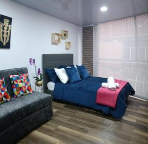 波哥大Nuevo Loft completo 34 Corferias Movistar Arena Campin HOST-MI的一间卧室配有蓝色的床和沙发