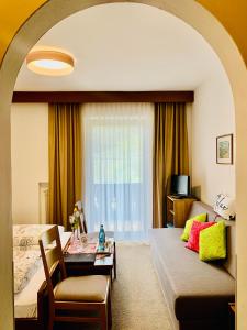 CainesTannerhof Bed & Breakfast的酒店客房配有床、沙发和桌子。
