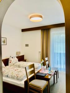 CainesTannerhof Bed & Breakfast的卧室配有一张床和一张桌子及椅子