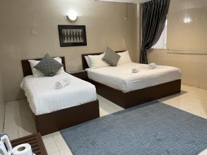 太平巴拉克街酒店的酒店客房带两张床和蓝色地毯
