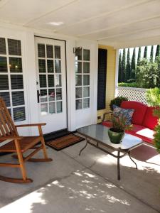 阿什兰Bayberry Inn B&B and Oregon Wellness Retreat的一个带红色沙发和玻璃桌的庭院