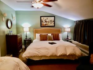 阿什兰Bayberry Inn B&B and Oregon Wellness Retreat的一间卧室配有一张大床和吊扇