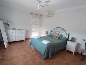 乌特雷拉Casa Rural El Algarrobo的一间卧室配有绿色的床和梳妆台