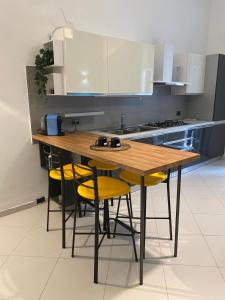 滨海波利尼亚诺Casa Margherita Stefy - locazione turistica的厨房配有木桌和黄色椅子