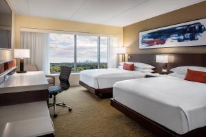 费城Delta Hotel Philadelphia Airport的酒店客房配有两张床和一张书桌