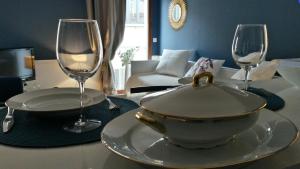 普罗旺斯艾克斯Center of Aix - charmful 1 bedroom aptmt Pythagore with parking的一张桌子,上面放着碗和两杯酒杯