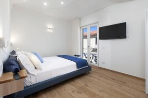 索伦托YourHome - Lidia Rooms & Suites的一间卧室配有一张床和一台平面电视