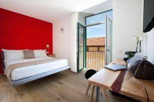 索伦托YourHome - Lidia Rooms & Suites的一间卧室设有红色的墙壁、一张床和一张书桌
