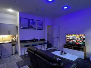 WibseyLuxe Loft Living: A Home Away From Home的带沙发的客厅和带紫色墙壁的厨房