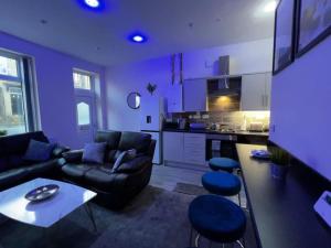 WibseyLuxe Loft Living: A Home Away From Home的紫色的客厅配有沙发和桌子