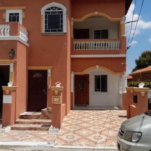 Spanish TownRoyal Vybez Vacation Homes的橙色的建筑,设有阳台和门